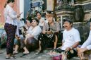Sebuah keluarga sedang melihat brosur destinasi wisata dengan ekspresi mempertimbangkan, di hadapan mereka terpampang daftar harga tiket masuk ke berbagai objek wisata populer yang terus meningkat. Gambar ini merefleksikan dilema banyak wisatawan dalam merencanakan liburan dengan anggaran terbatas.