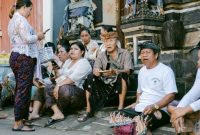Sebuah keluarga sedang melihat brosur destinasi wisata dengan ekspresi mempertimbangkan, di hadapan mereka terpampang daftar harga tiket masuk ke berbagai objek wisata populer yang terus meningkat. Gambar ini merefleksikan dilema banyak wisatawan dalam merencanakan liburan dengan anggaran terbatas.