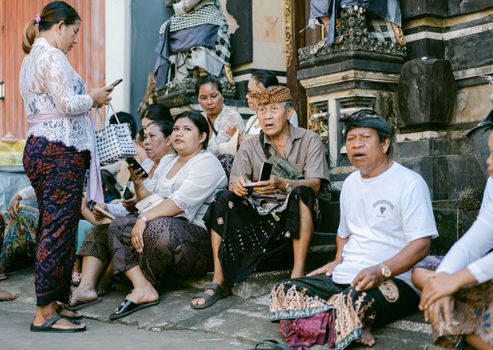 Sebuah keluarga sedang melihat brosur destinasi wisata dengan ekspresi mempertimbangkan, di hadapan mereka terpampang daftar harga tiket masuk ke berbagai objek wisata populer yang terus meningkat. Gambar ini merefleksikan dilema banyak wisatawan dalam merencanakan liburan dengan anggaran terbatas.