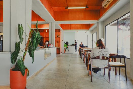 Sebuah kafe modern dengan dominasi kaca di Sentul, dikelilingi oleh pepohonan rindang dan menawarkan pemandangan alam yang menenangkan, menjadi tempat ideal untuk menikmati kopi di tengah hijaunya perbukitan.